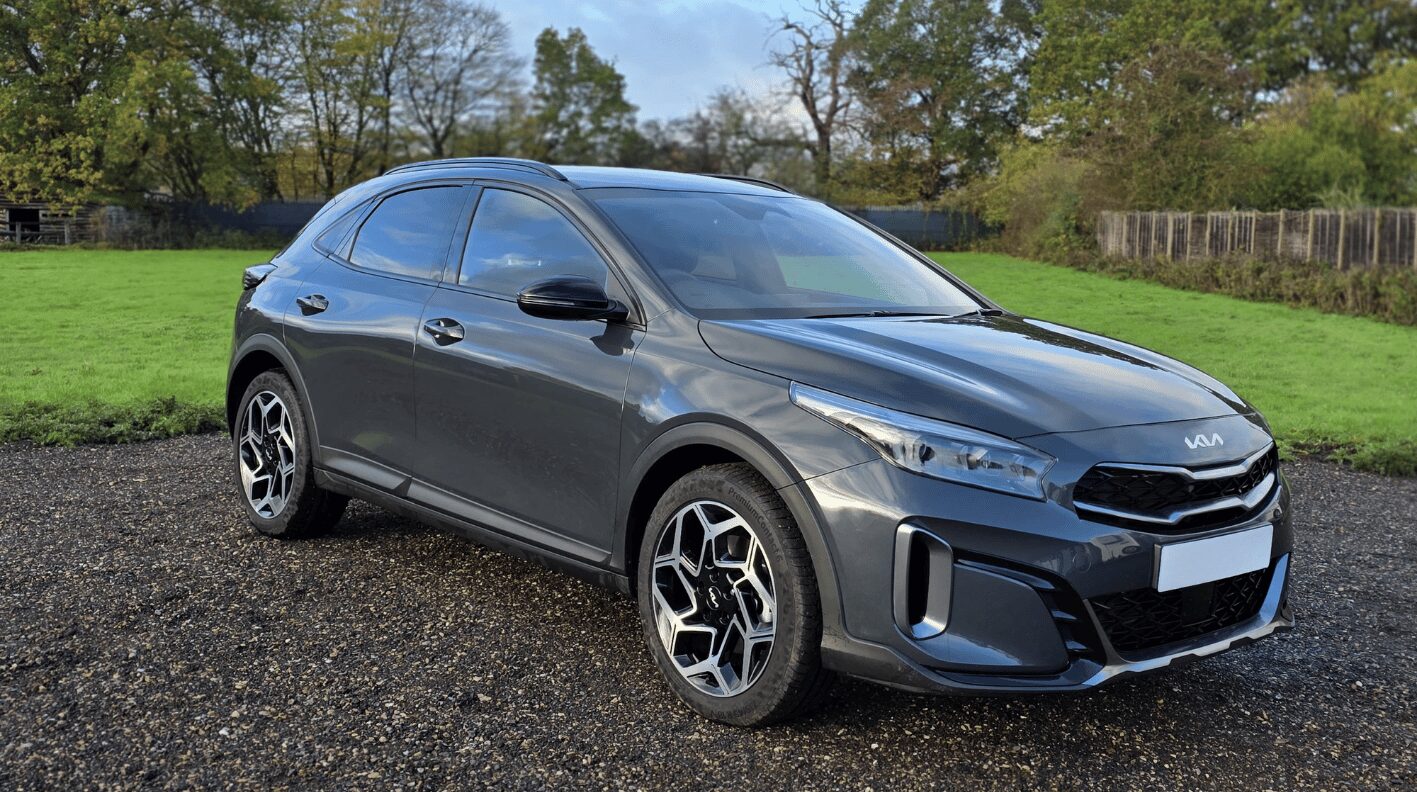Grey KIA car with grass and trees in the background - a car available for hire in Hertfordshire